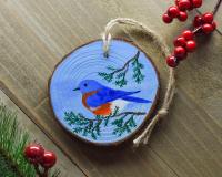 A hand-painted eastern bluebird wood slice Christmas ornament at Cove Creek Photography.