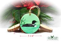 A wood slice with a hand-painted common loon at www.covecreekphotography.com.