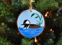 Hand-painted male hooded merganser on a wood slice ornament hanging on a Christmas tree at www.covecreekphotography.com.