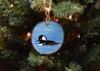 A hand-painted wood slice Christmas ornament with a hooded merganser available at Cove Creek Photography.
