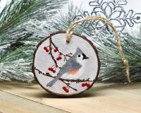A handmade Christmas ornament with a tufted titmouse hand-painted on a wood slice at covecreekphotography.com.