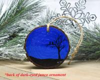 A hand-painted starry night with tree and birds silhouette on a wood slice ornament at Cove Creek Photography.