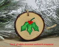 Hand-painted holly leaves with red berries on the back of a nuthatch wood slice ornament at covecreekphotography.com.
