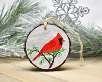 An acrylic painting of a male northern cardinal on a three inch wood slice at covecreekphotography.com.