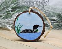 A common loon on a pond hand-painted on a three inch wood slice Christma ornament at Cove Creek Photography.