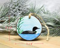 Measurements are displayed on an image of a hand-painted common loon wood slice Christmas ornament at covecreekphotography.com.