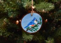 A hand-painted tufted titmouse on a wood slice Christmas ornament available at covecreekphotography.com.