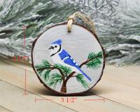 An image of a hand-painted blue jay wood slice Christmas ornament with the 3.5 inch diameter displayed in red on each side of the ornament.