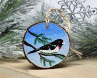 A handmade rose-breasted grosbeak wood slice Christmas ornament at covecreekphotography.com.