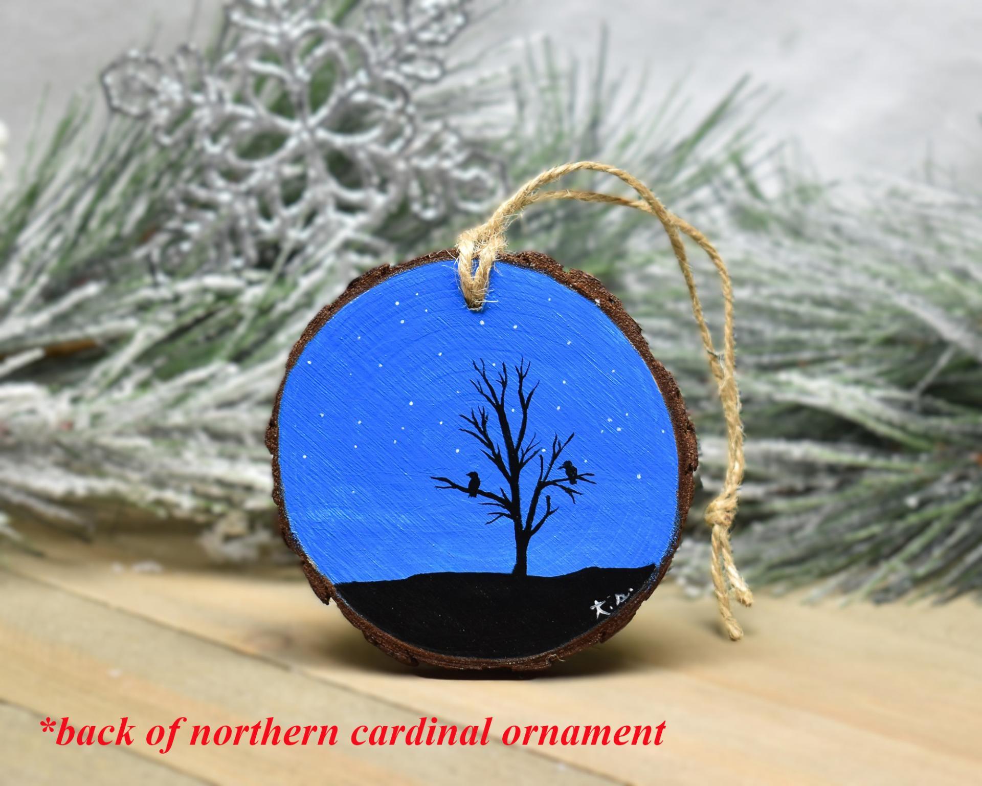A night sky with bird and tree silhouettes hand-painted on a wood slice at covecreekphotography.com.
