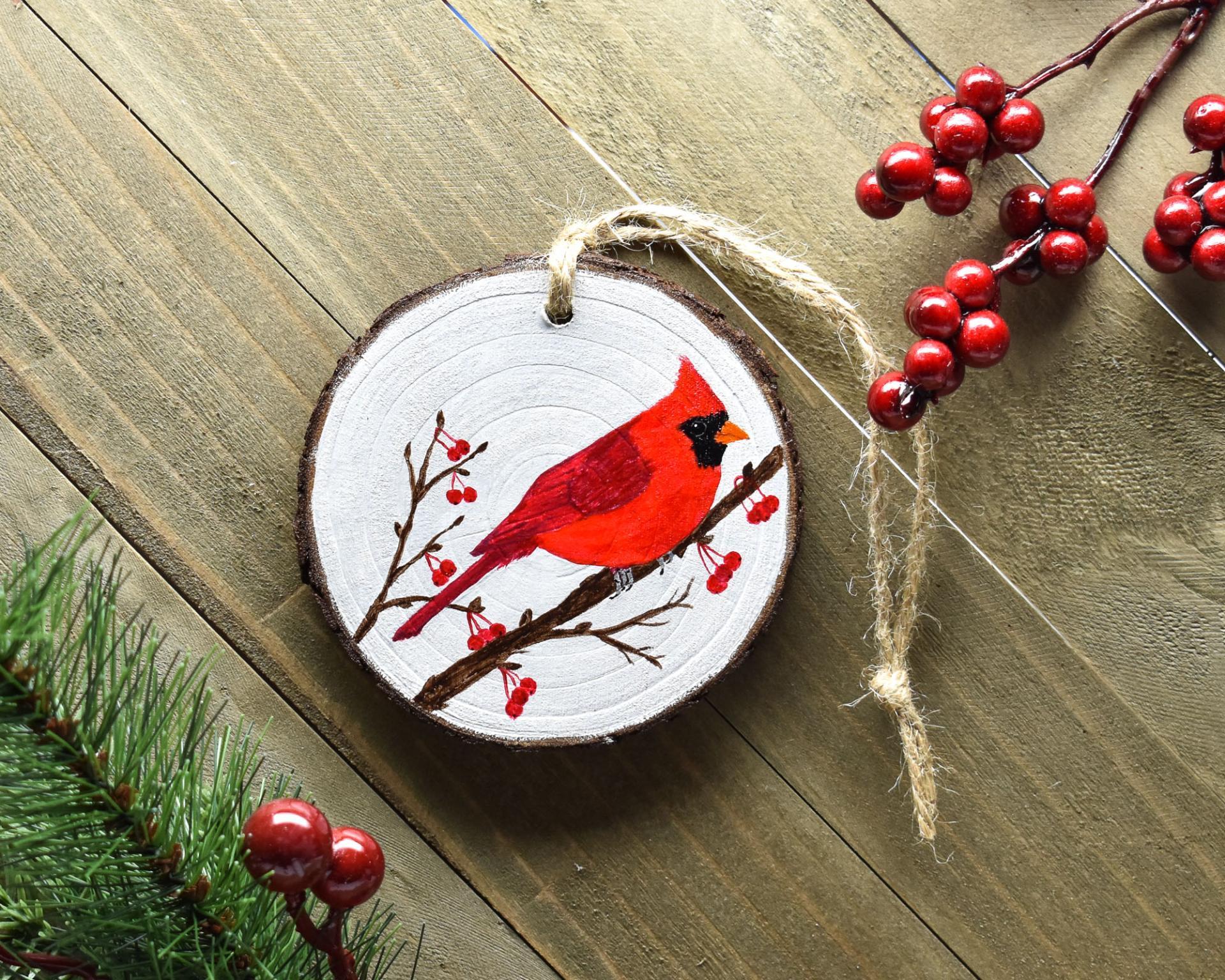A handmade northern cardinal wood slice Christmas ornament at Cove Creek Photography.
