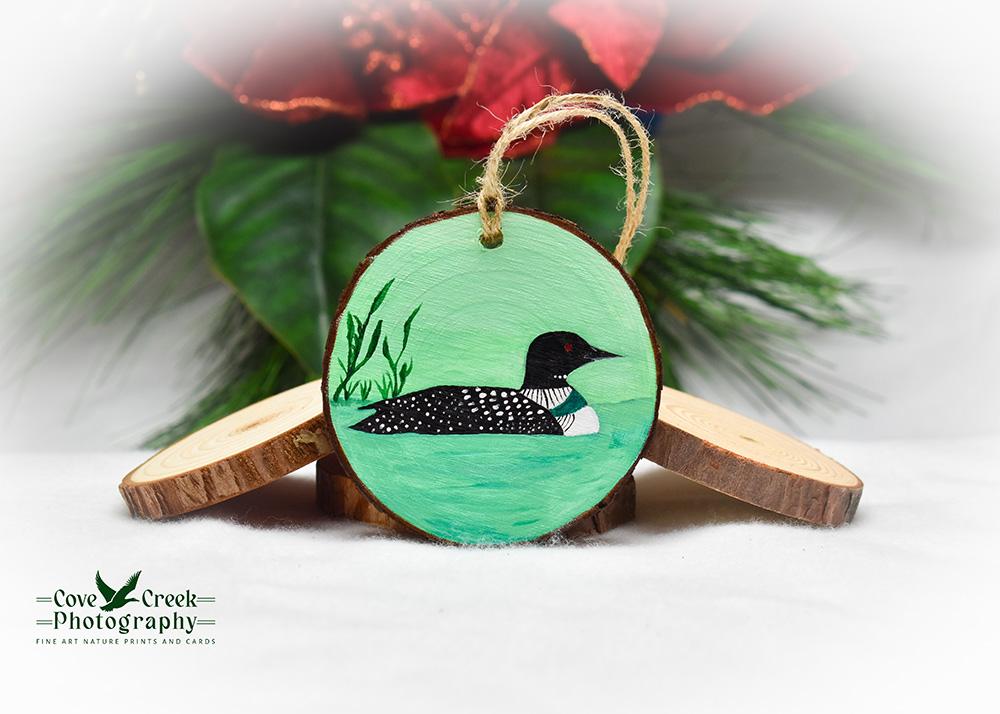 A hand-painted common loon on a pond wood slice ornament available for purchase at Cove Creek Photography.
