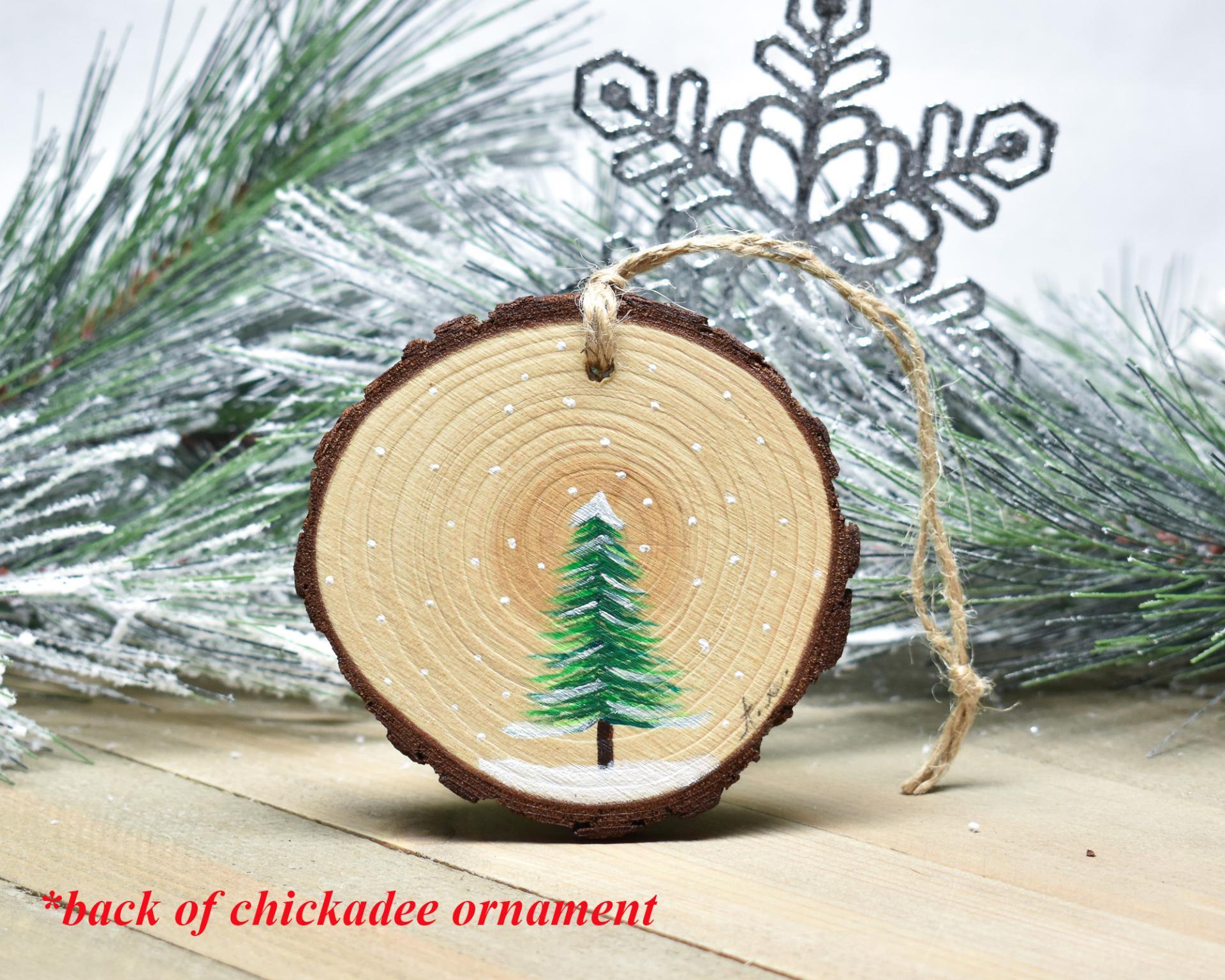 A simple evergreen tree hand-painted on a wood slice at Cove Creek Photography.