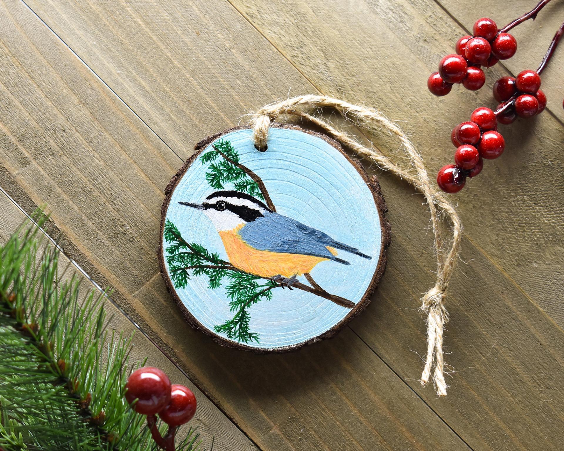 A handmade red-breasted nuthatch wood slice ornament at covecreekphotography.com.