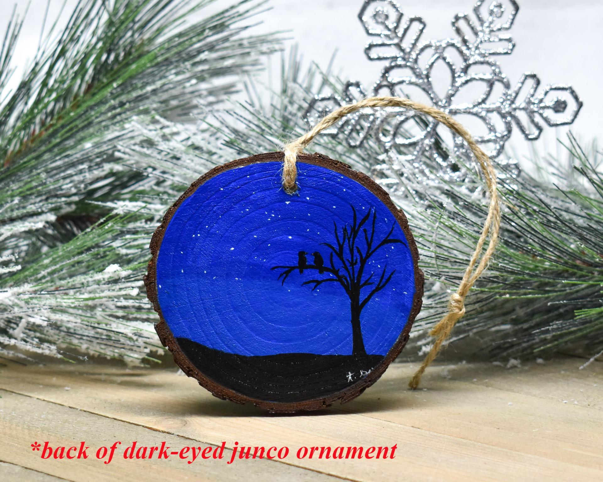 A hand-painted starry night with tree and birds silhouette on a wood slice ornament at Cove Creek Photography.