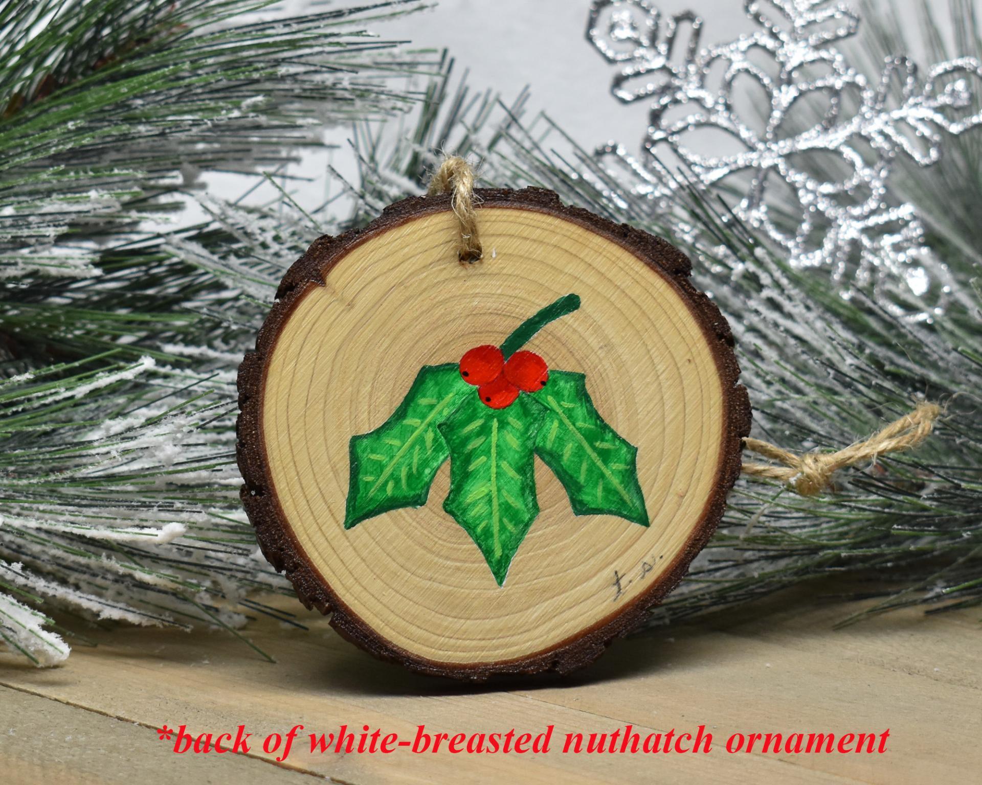 Hand-painted holly leaves with red berries on the back of a nuthatch wood slice ornament at covecreekphotography.com.