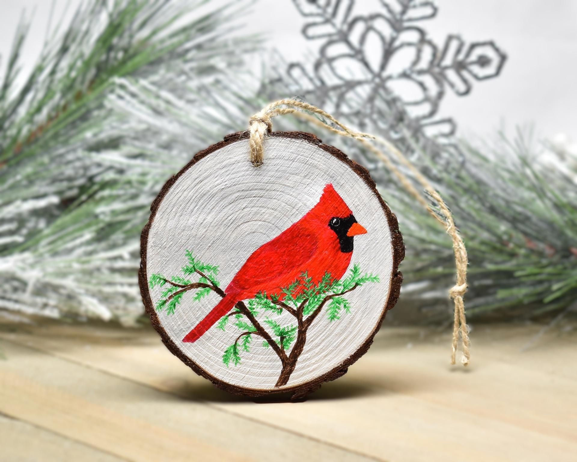 An acrylic painting of a male northern cardinal on a three inch wood slice at covecreekphotography.com.