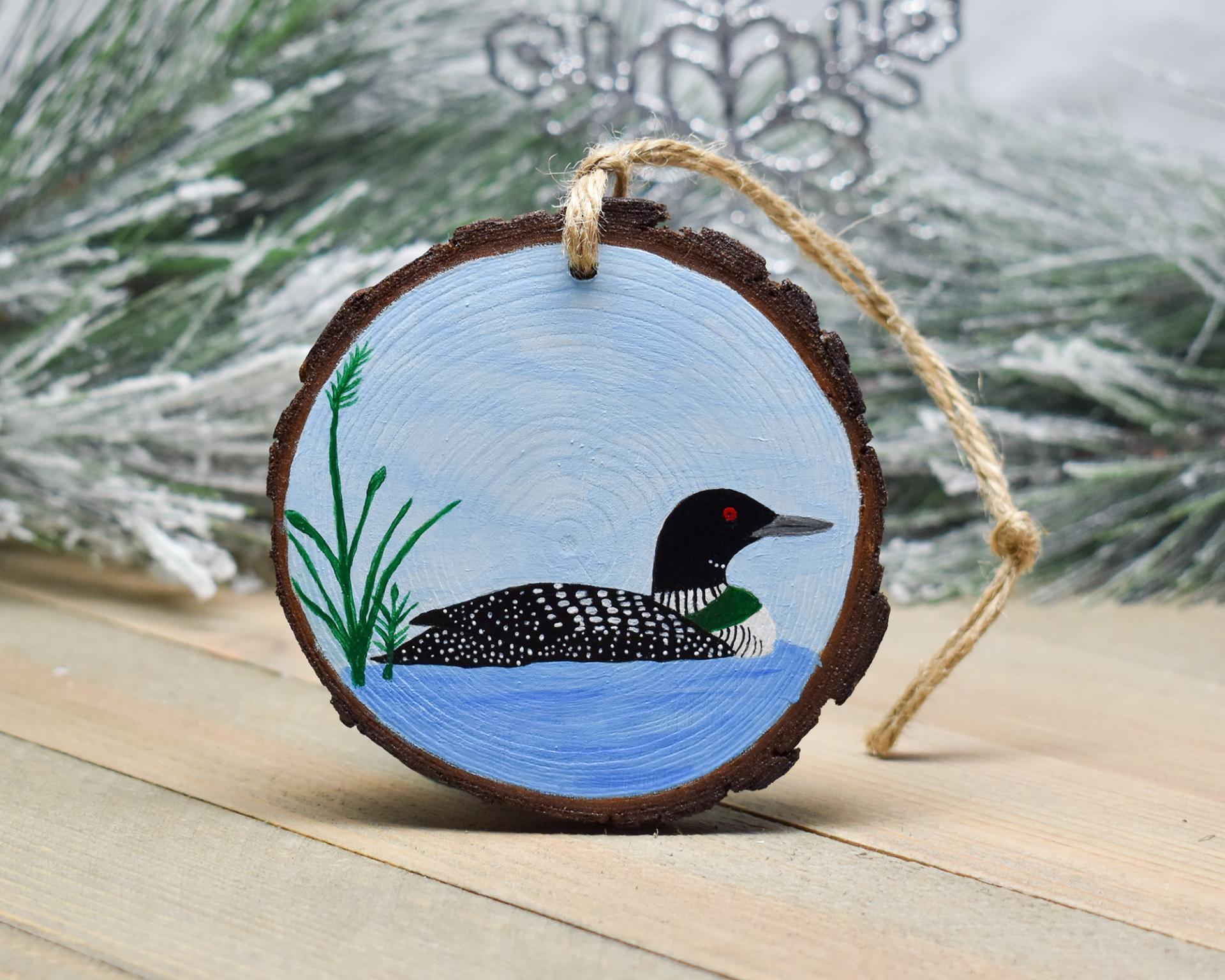 A common loon on a pond hand-painted on a three inch wood slice Christma ornament at Cove Creek Photography.