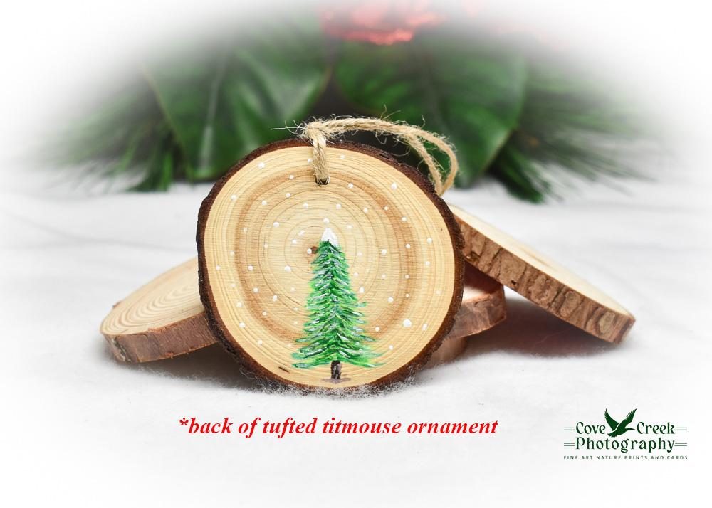 Hand-painted Christmas tree on the back of a hand-painted tufted titmouse wood slice ornament.