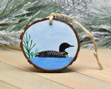 A common loon on blue water hand-painted on a three inch wood slice Christmas ornament at Cove Creek Photography.