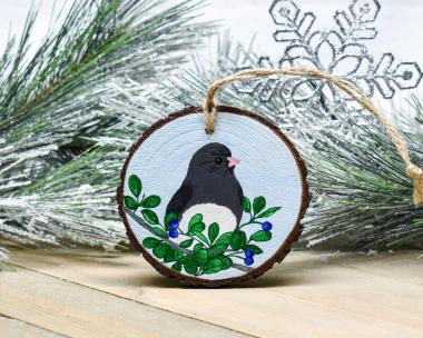 An acrylic painting of a dark-eyed junco on a wood slice ornament at covecreekphotography.com.